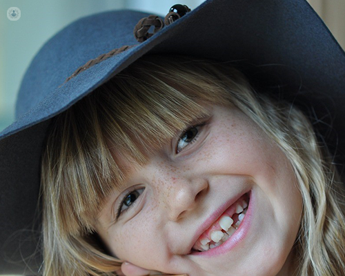A smiling child with a gap in their front teeth