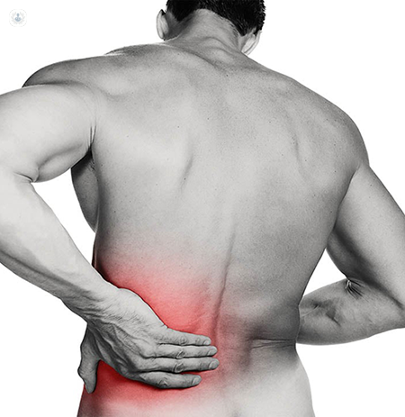 Man with a herniated disc, holding his back in a painful spot