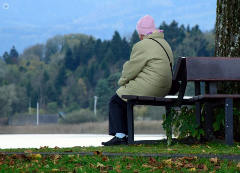 Woman with polymyalgia rheumatica sat on a bench