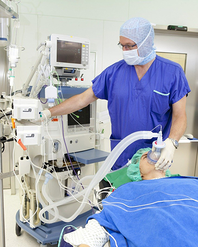 Doctor administering general anaesthesia by gas.