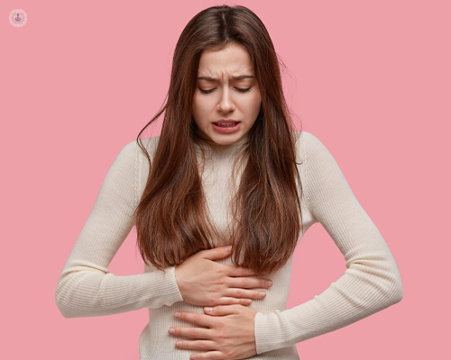Girl with acid reflux stood against pink background