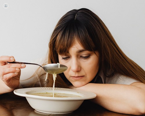 Woman with a taste disorder trying to eat soup