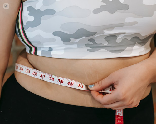 A woman measuring her stomach