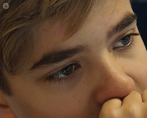 A close up of a teenage boy's face. He is looking into the distance and is contemplating many thoughts.