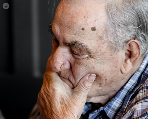 Man with Alzheimer's with his eyes closed while holding his chin