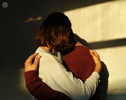 Two people in a deep embrace. Their faces are not visible.