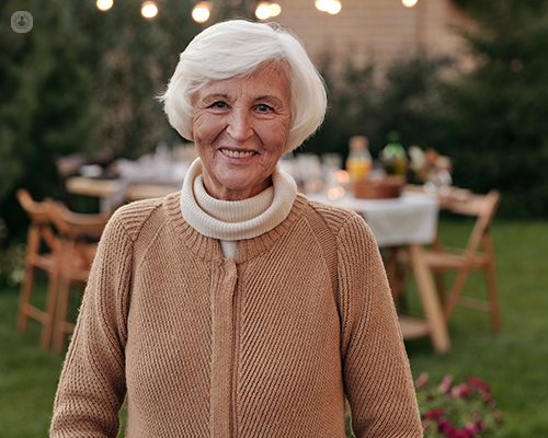 An elderly woman smiling and looking at the camera