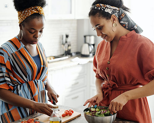 Two women prepare a salad together. People with Crohn's disease must take precautions with their diet.