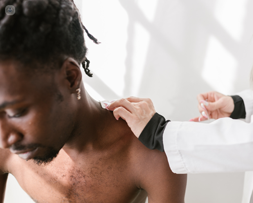 Young black man with shoulder pain being treated