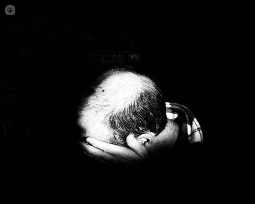 Black and white photo focused on the top of the head of a man who's balding
