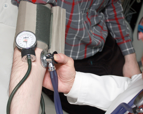 Doctor treating someone with high blood pressure which can lead to heart disease
