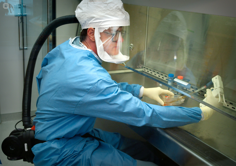 A man in a soecial suit testing coronavirus samples.